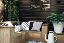 25 small rustic L-shaped wooden bench with graphic pillows for a Nordic terrace