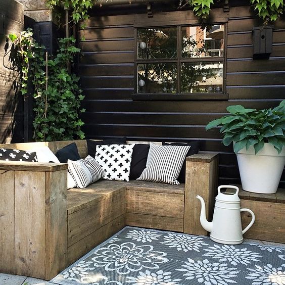 25 small rustic L shaped wooden bench with graphic pillows for a Nordic terrace