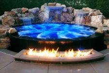 26 a spectacular blue jacuzzi clad with black tiles and with waterfalls