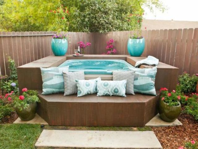 wood surround doubles as raised seating and hydrangeas joined by potted blooms make this space quite the charmer