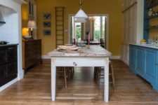 02 All the walls are sunny yellow, the shelving unit is bold blue, and there are some cream-colored cupboards