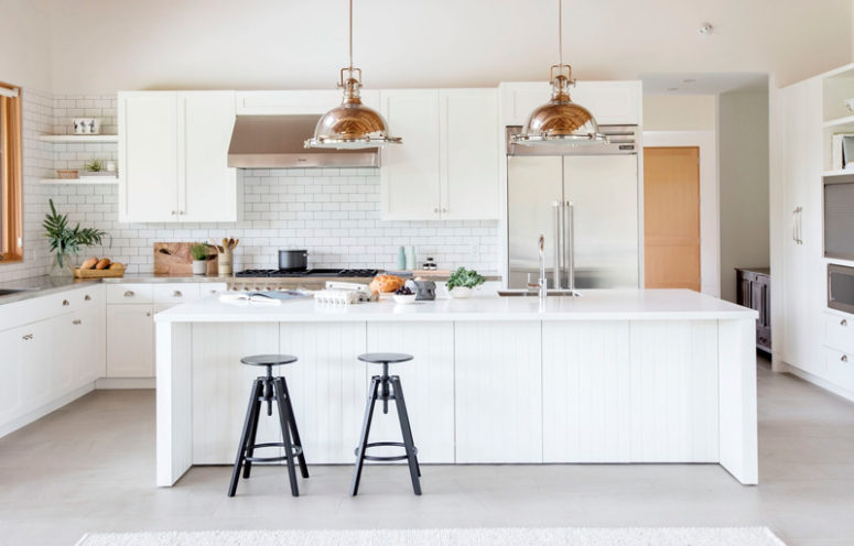 large, all white kitchen island design The kitchen features white cabinets and tiles, a large kitchen island and stainless steel countertops