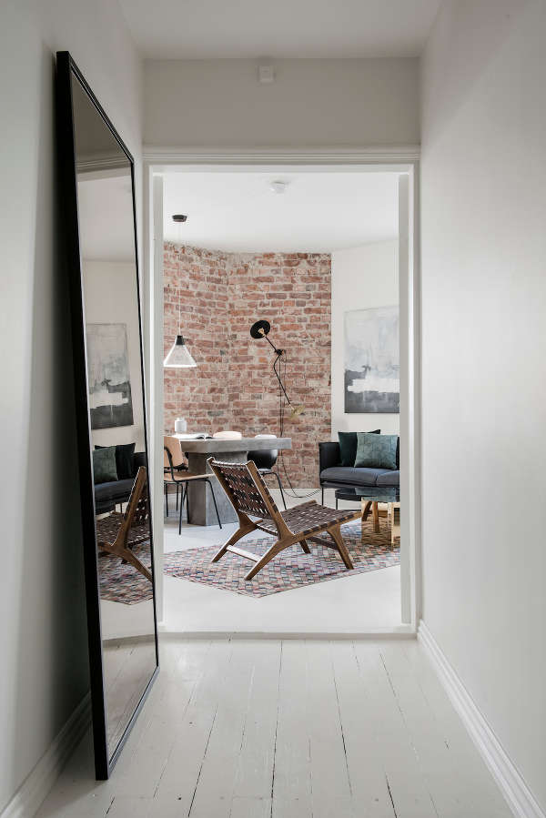 The living room features a brick wall and a concrete table, the furniture is comfy and very eye catchy, look at this leather woven chair The living room features a brick wall and a concrete table, the furniture is comfy and very eye-catchy, look at this leather woven chair