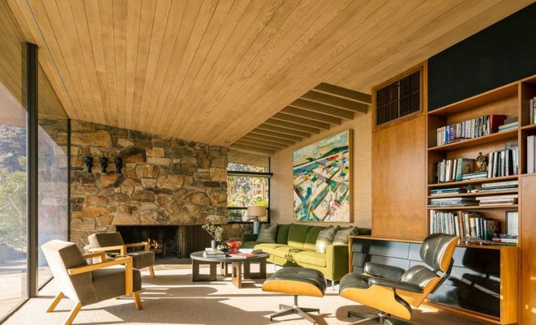 wood ceiling design The living room features a natural wood ceiling with beams, s tone clad wall with a fireplace and a fine selection of comfy mid-century furniture