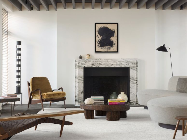 The living room features herringbone floors, wooden beams on the ceiling and a marble fireplace plus designer furniture The living room features herringbone floors, wooden beams on the ceiling and a marble fireplace plus designer furniture