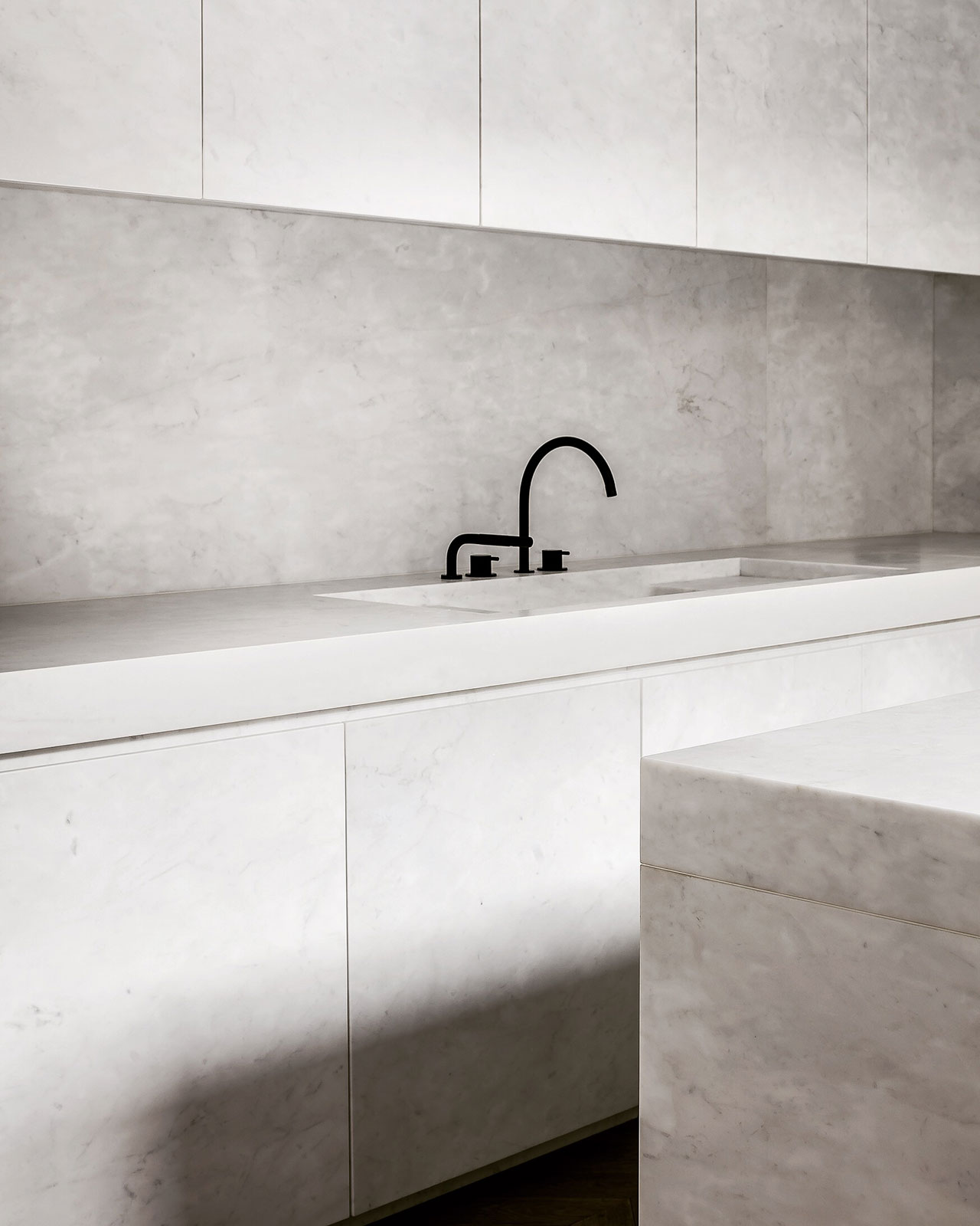 The kitchen is refined, fully clad with white marble and very chic, everything hidden and uncluttered