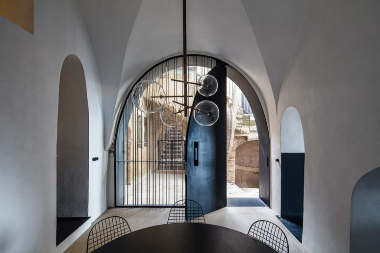 amazing modern chandelier This is an entrance with a black tin door, a black table and metal chairs and a cool modern glass bubble chandelier