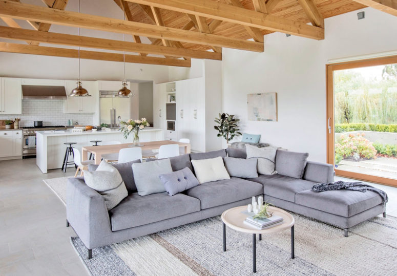 The living space features a large corner grey sofa, a comfy rug and those wooden beams on the ceiling add coziness