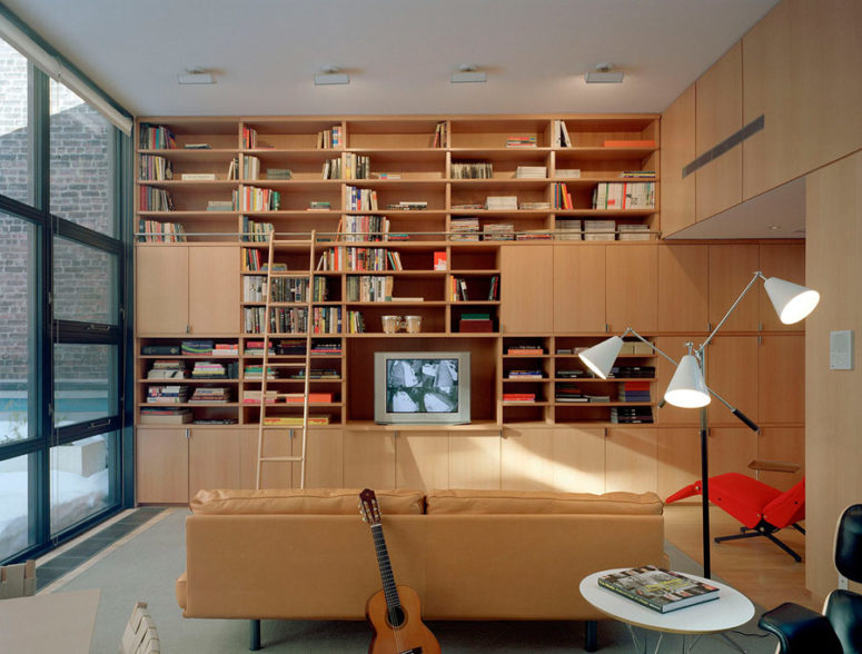 home library design There's a library, fully decorated with light-colored wood, which makes it cozy and inviting, and there's a beige leather sofa