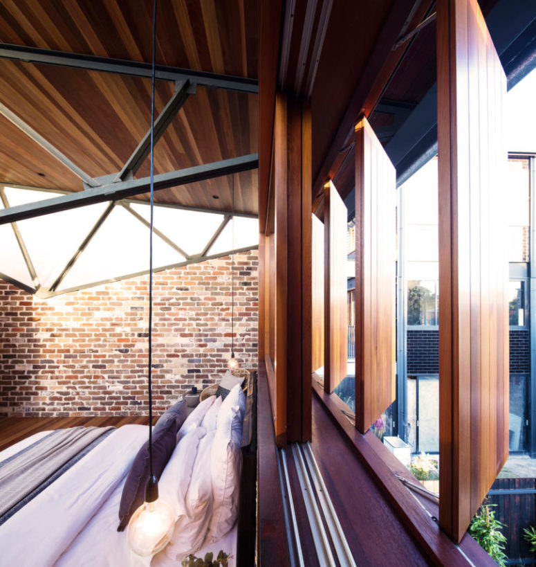 This is the master bedroom, industrial and laconic, with brick walls, lots of wood, industrial bulbs and shutters