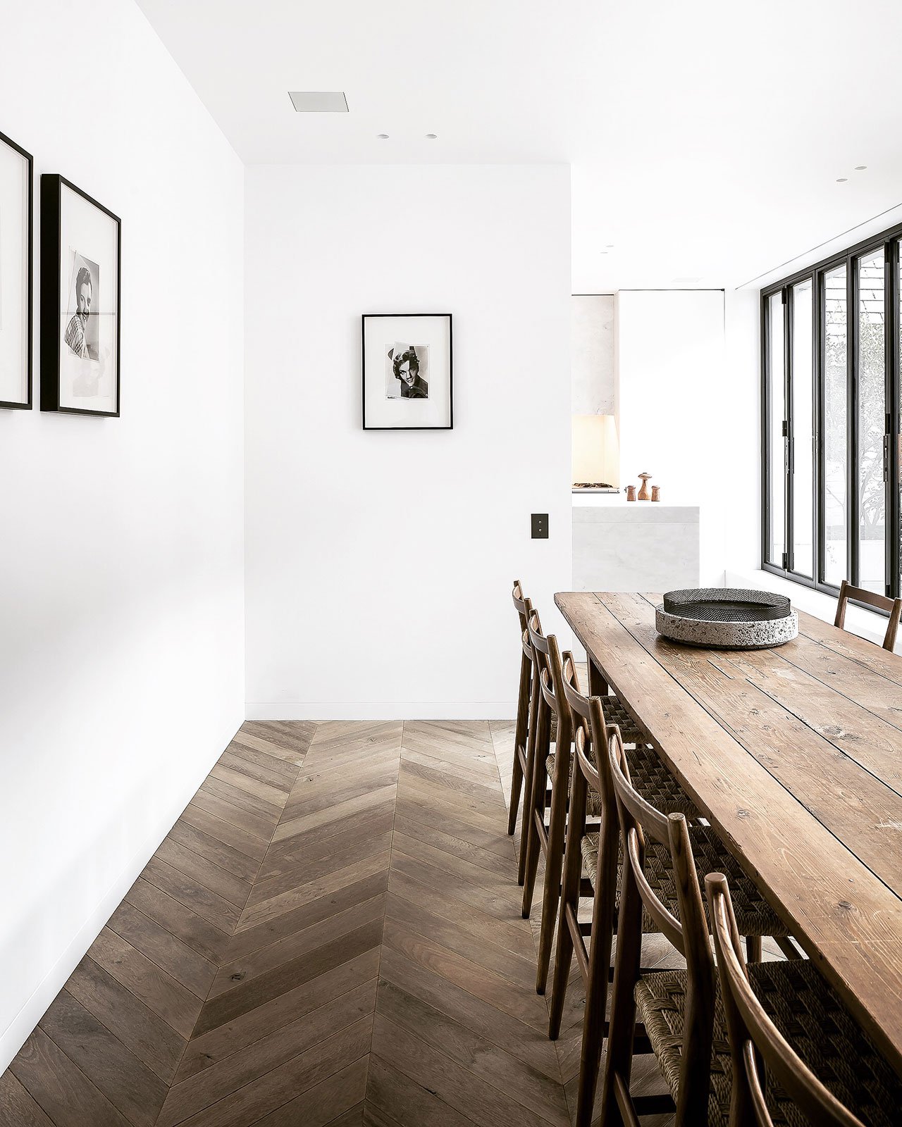 The dining space with a rustic wooden dining set is separated from the kitchen with a half wall