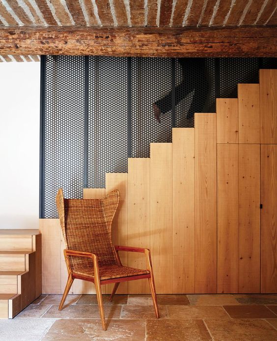 The stairs is made of light colored wood, there's a wicker chair and a restored wooden ceiling for coziness The stairs is made of light-colored wood, there's a wicker chair and a restored wooden ceiling for coziness