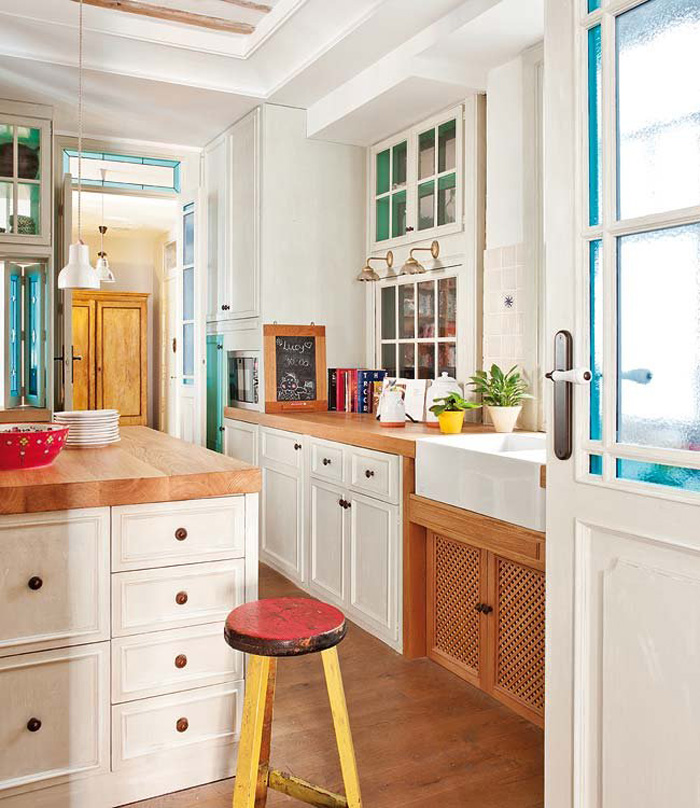 The kitchen is vintage meets mid century modern, with traditional white cabinets and warm wood counters The kitchen is vintage meets mid-century modern, with traditional white cabinets and warm wood counters