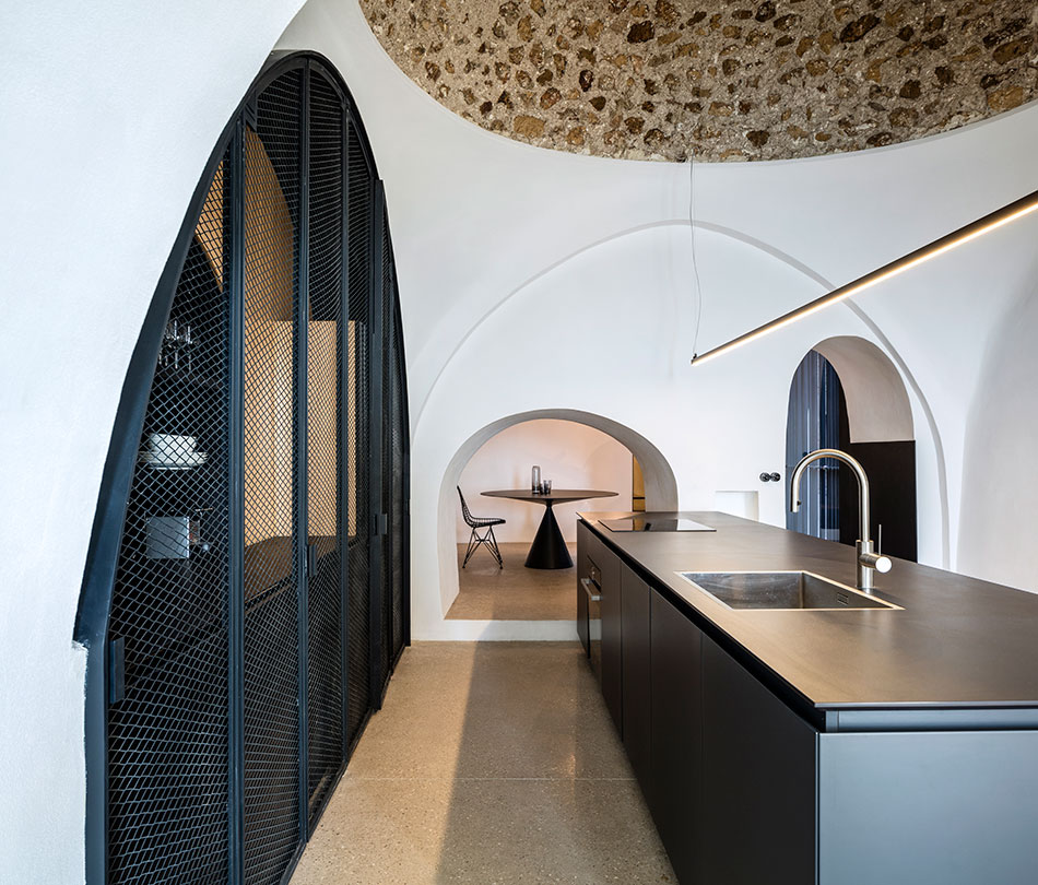 The ancient stone ceilings are neighboring with modern metal net doors and minimalist lights