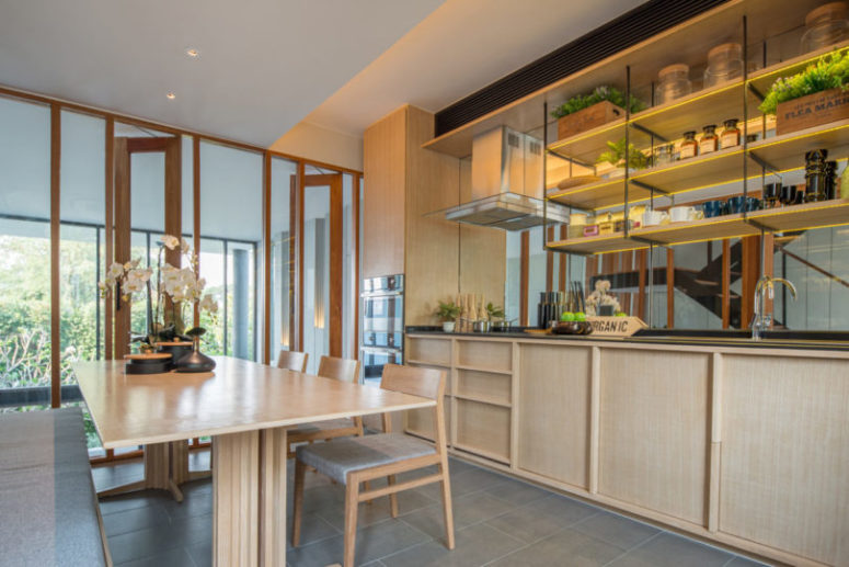 The kitchen is fully clad in light colored wood, which makes it cozy and inviting and a glazed wall fills it with light The kitchen is fully clad in light-colored wood, which makes it cozy and inviting and a glazed wall fills it with light