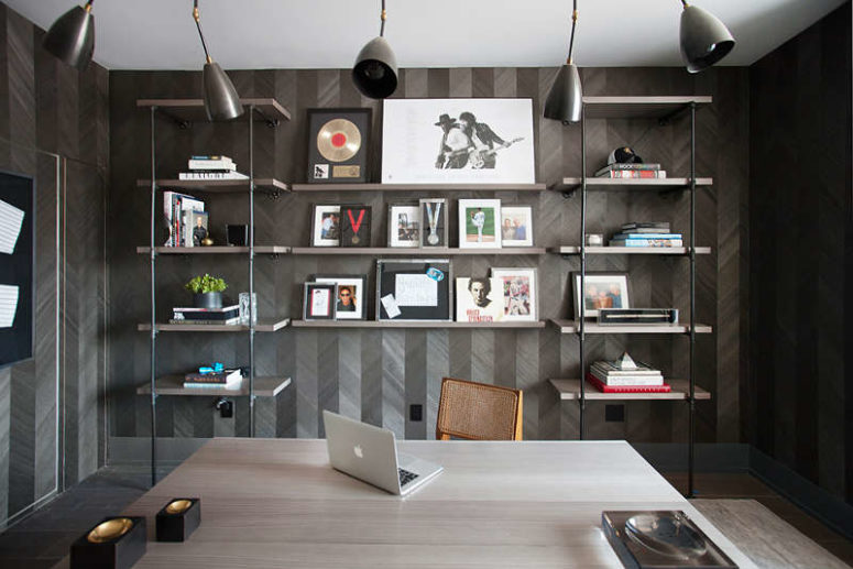 The home office is dark and moody, with unique wallpaper imitating reclaimed wood clad in a chevron pattern