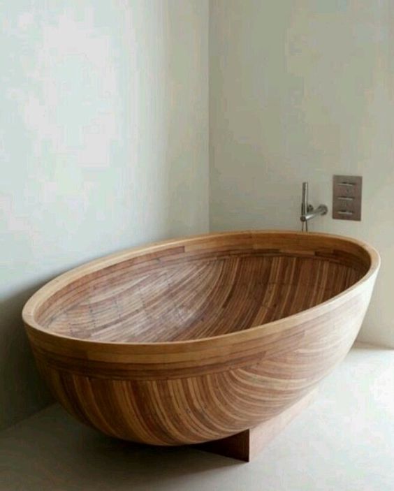 a wooden bathtub  of a beautiful half coconut shell shape