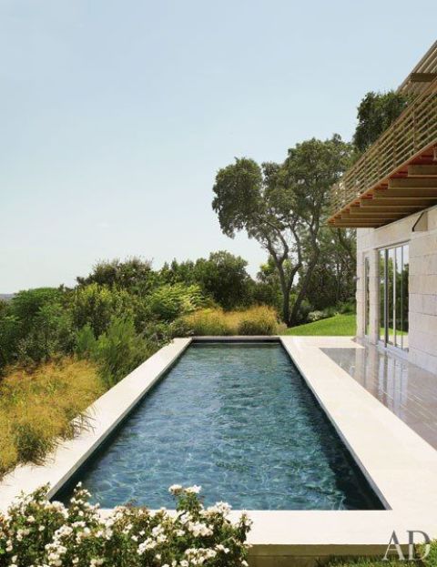 a simple modern narrow pool with a gorgeous view and a deck next to it