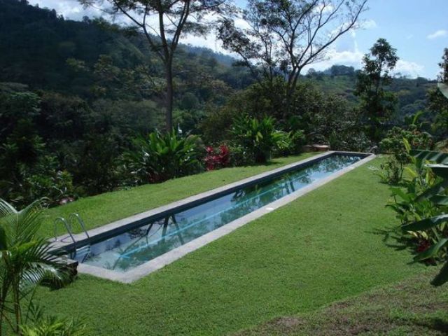 modern lap pool surrounded by perfectly manicured lawn and with great views