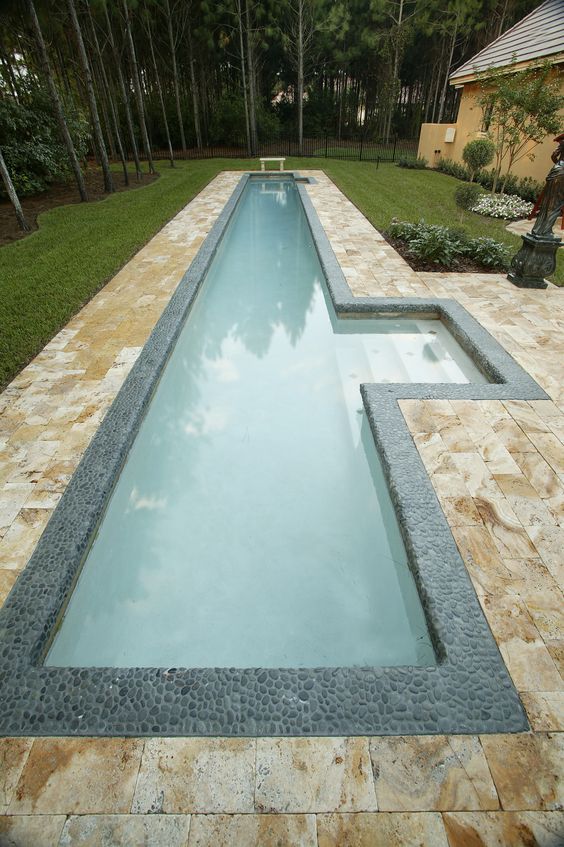 narrow pool with steps highlighted and clad with pebbles for a natural feel