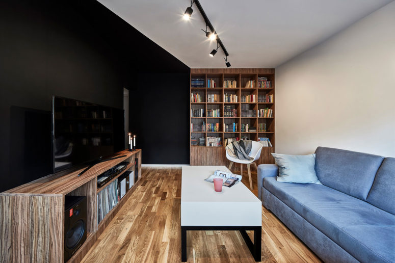 This compact Polish apartment is done in black and white with warm colored wooden touches that make it cozier and welcoming