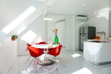 The attic kitchen is all-white, with a corner cooking space and a small dining area by the window
