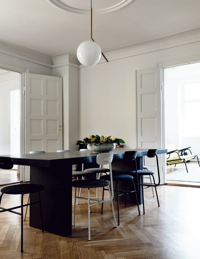 The dining space features a black modern dining set and a cool mid-century modern lamp over it, the accents are white on black