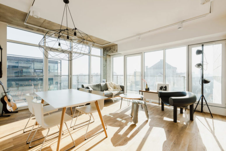 The open living and dining space layout shows off uninterrupted views and some modern furniture, I love the geo pendant lamp over the table The open living and dining space layout shows off uninterrupted views and some modern furniture, I love the geo pendant lamp over the table