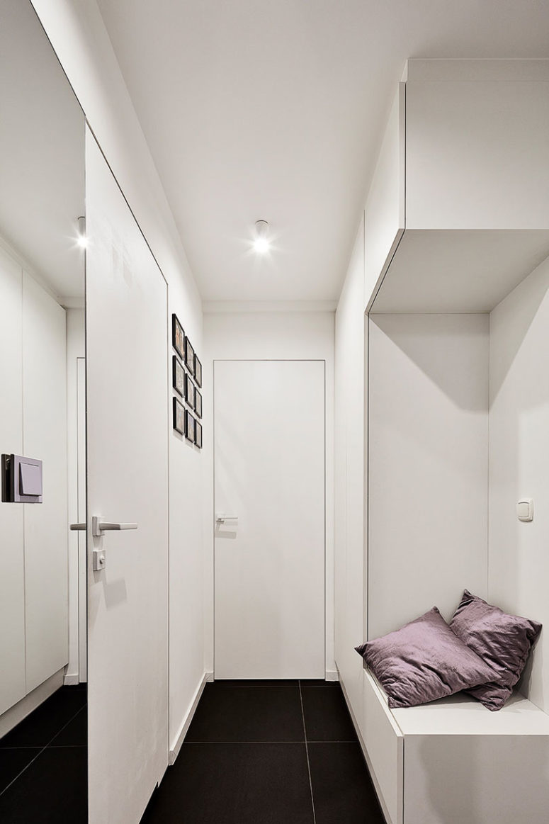 The entryway is all-white to make it look larger, and there's a smart storage unit with a seat