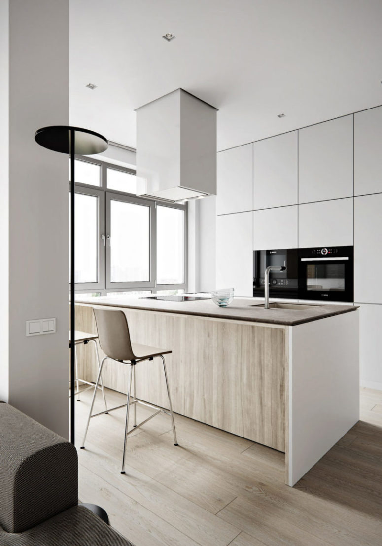 The kitchen features light colored cabinets with no handles, a large kitchen island that doubles as a dining table The kitchen features light-colored cabinets with no handles, a large kitchen island that doubles as a dining table