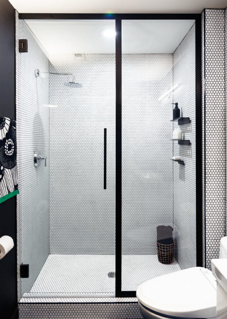 The shower has customized doors and black shelves
