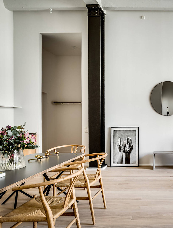 The dining space features a long dining table and comfy wooden chairs