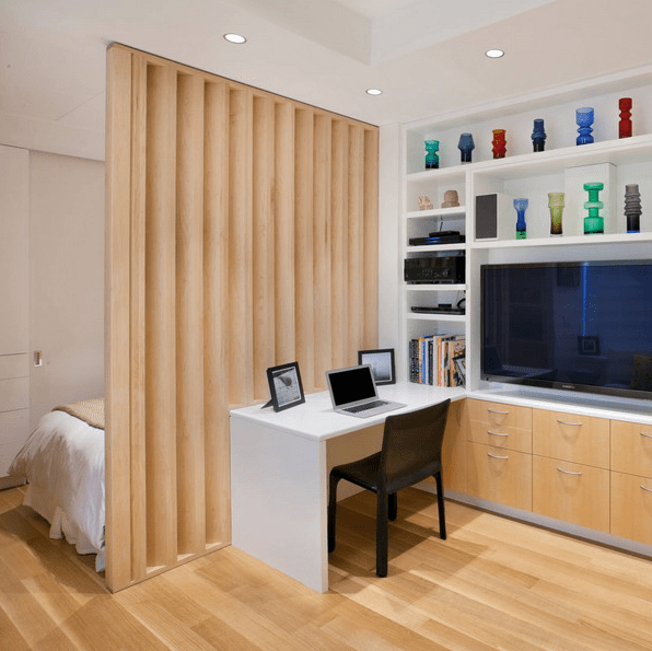 The home office features a small white desk and a lot of open shelves