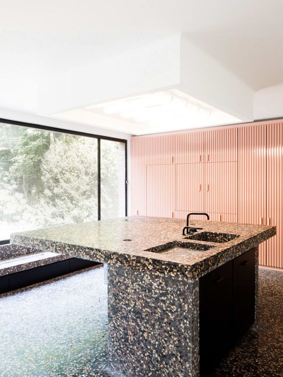 dark terrazzo kitchen island and floor look like a monolith