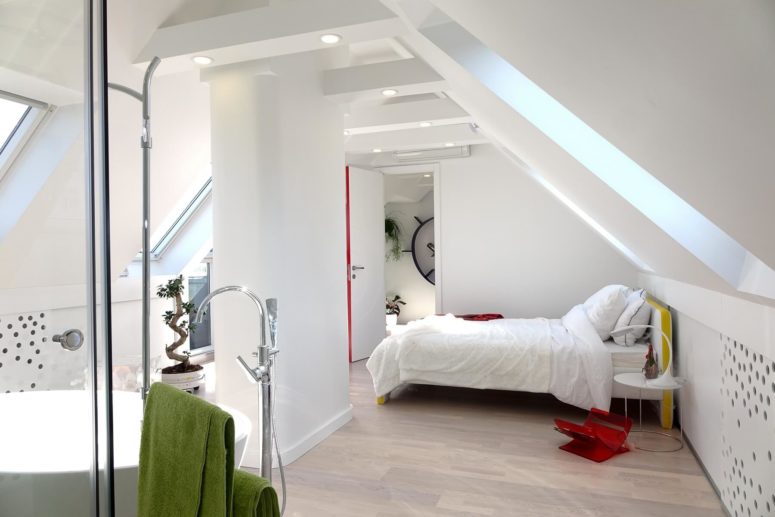 One of the attic bedrooms features an open bathroom with a bathtub, a shower and a sink with a stand