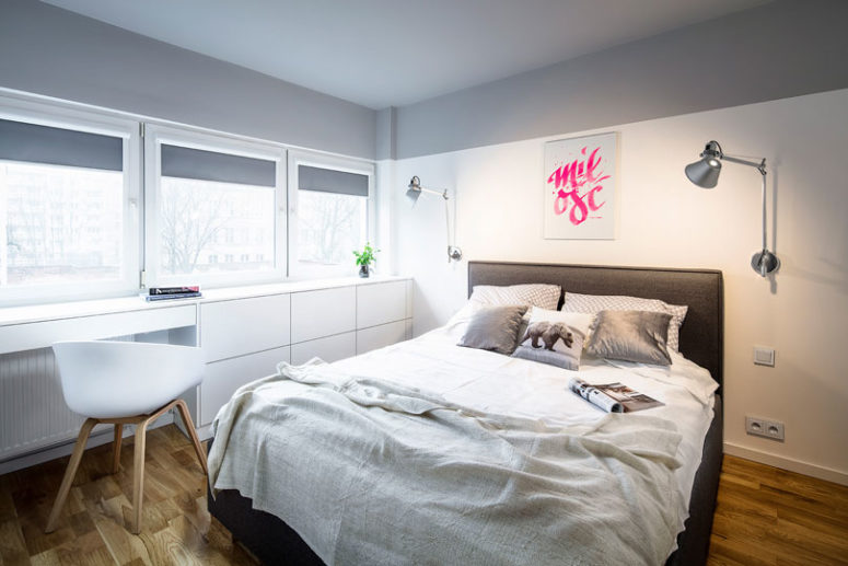 The bedroom is done in soothing grey and white for a relaxing atmosphere, and the window sill is smartly used as a desk and for storage