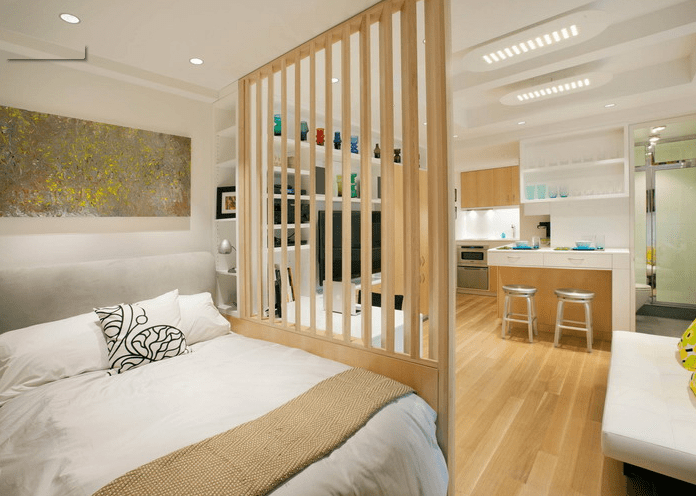 The bedroom is very small and is hidden behind a vertical wooden plank screen
