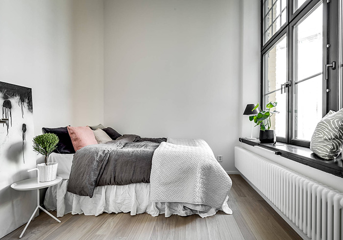 The master bedroom is peceful and comfortable, with shades of grey and some black touches