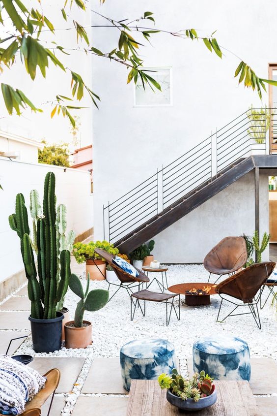 boho outdoor living room with a fire pit, leather chairs and indigo textiles