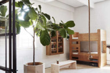07 The kid’s space continues the loft decor style with white brick walls, simple wooden furniture and a framed glass door