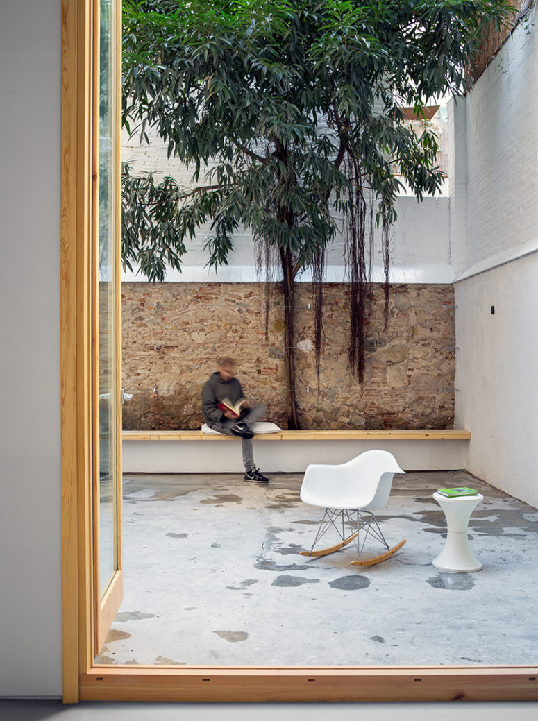 patio decor The patio is decorated in a minimalist way, with a long wooden bench and some modern furniture