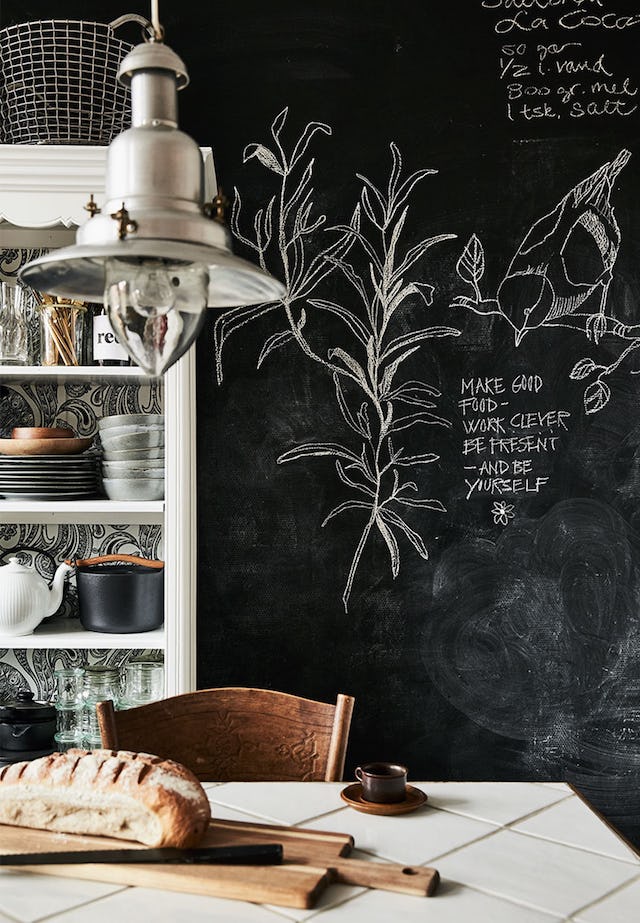 The sideboard features black and white wallpaper and there's a chalkboard wall for leaving messages