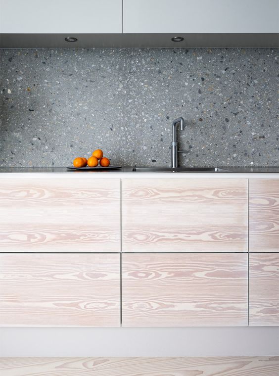 grey terrazzo kitchen backsplash contrasts the light colored cabinets