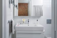 09 The bathroom is clad with white tiles, and the floor is done in grey graphic tiles, everything here is functional
