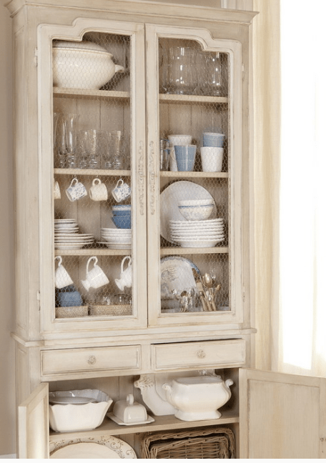 a neutral vintage cupboard with chicken wire instead of glass in doors