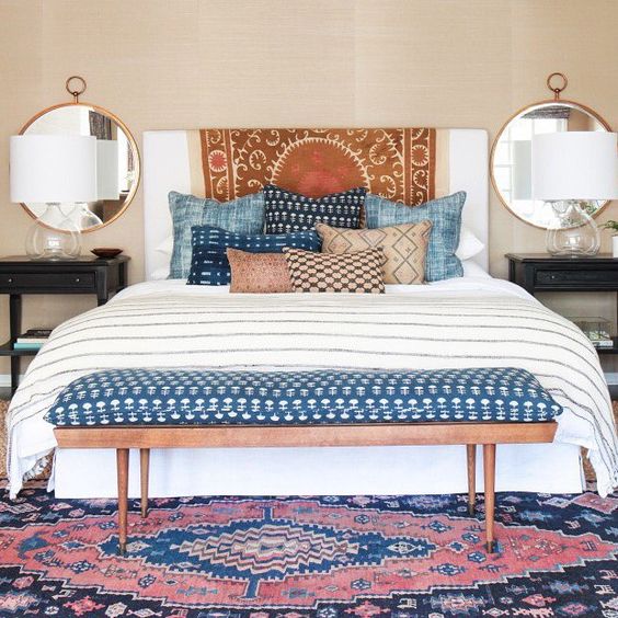 a striped throw and pillows cases with various prints look eye-catchy
