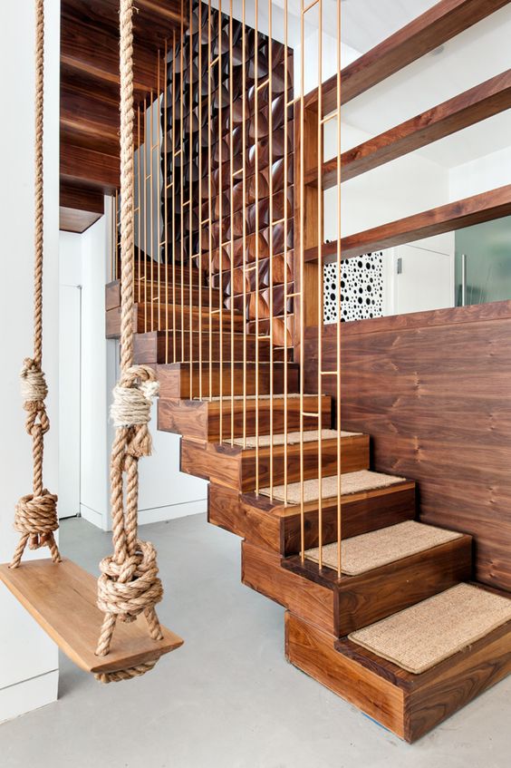 a wooden and rope swing can be an accent in the interior, like here it echoes with the stairs
