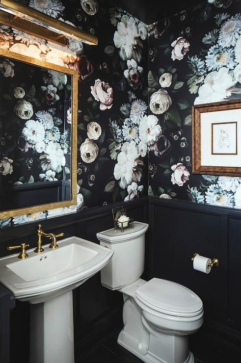 gorgeous powder room lined with black wainscoting and moody realistic floral wallpaper