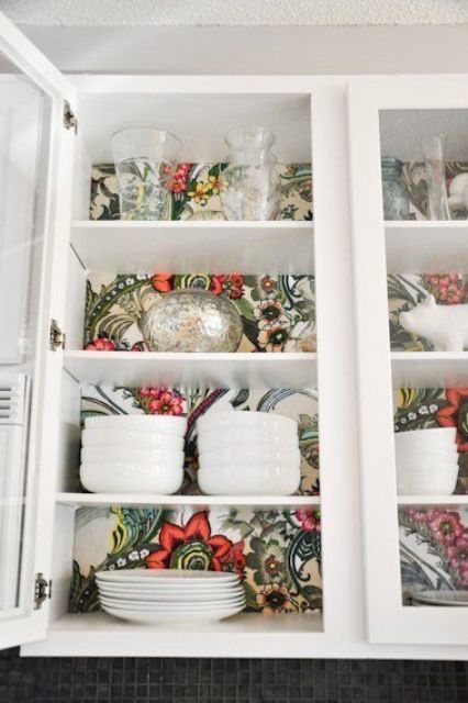 retro-inspired wallpaper inside a glass kitchen cabinet for a bold look