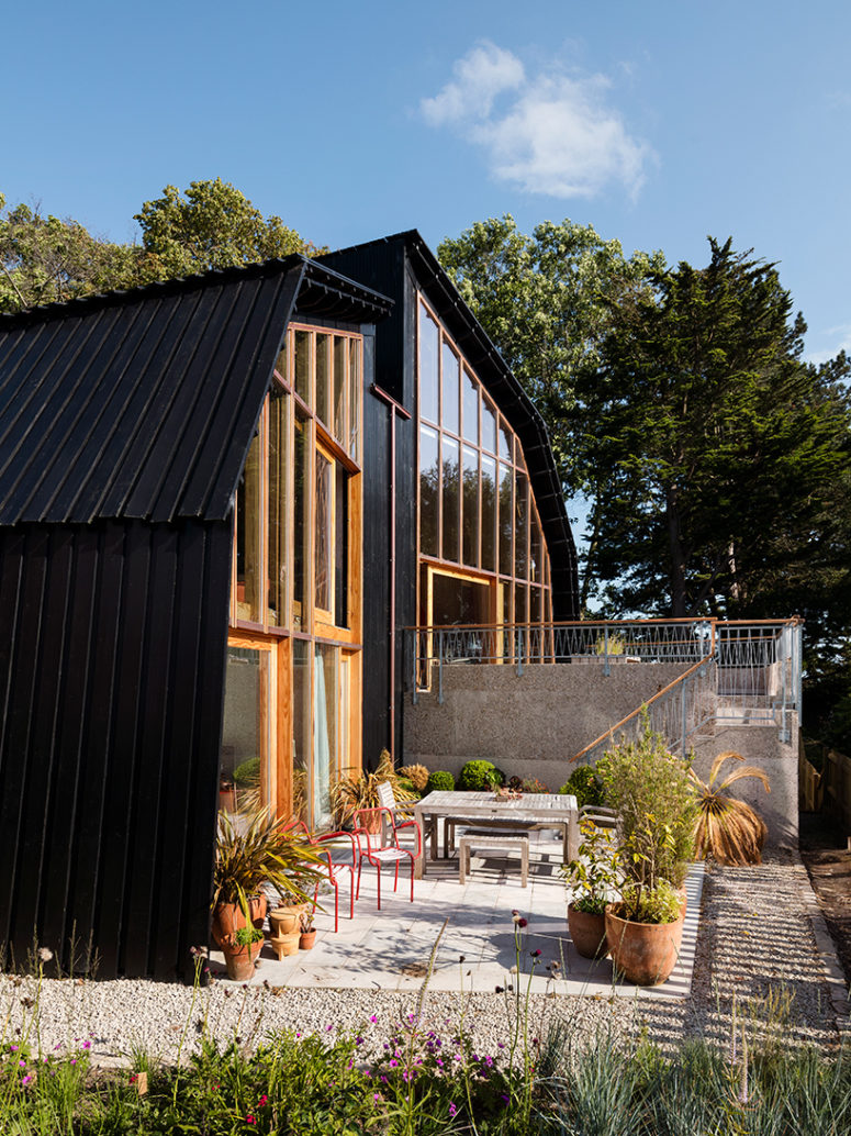 Black-stained timber larch boards sit above an exposed concrete base